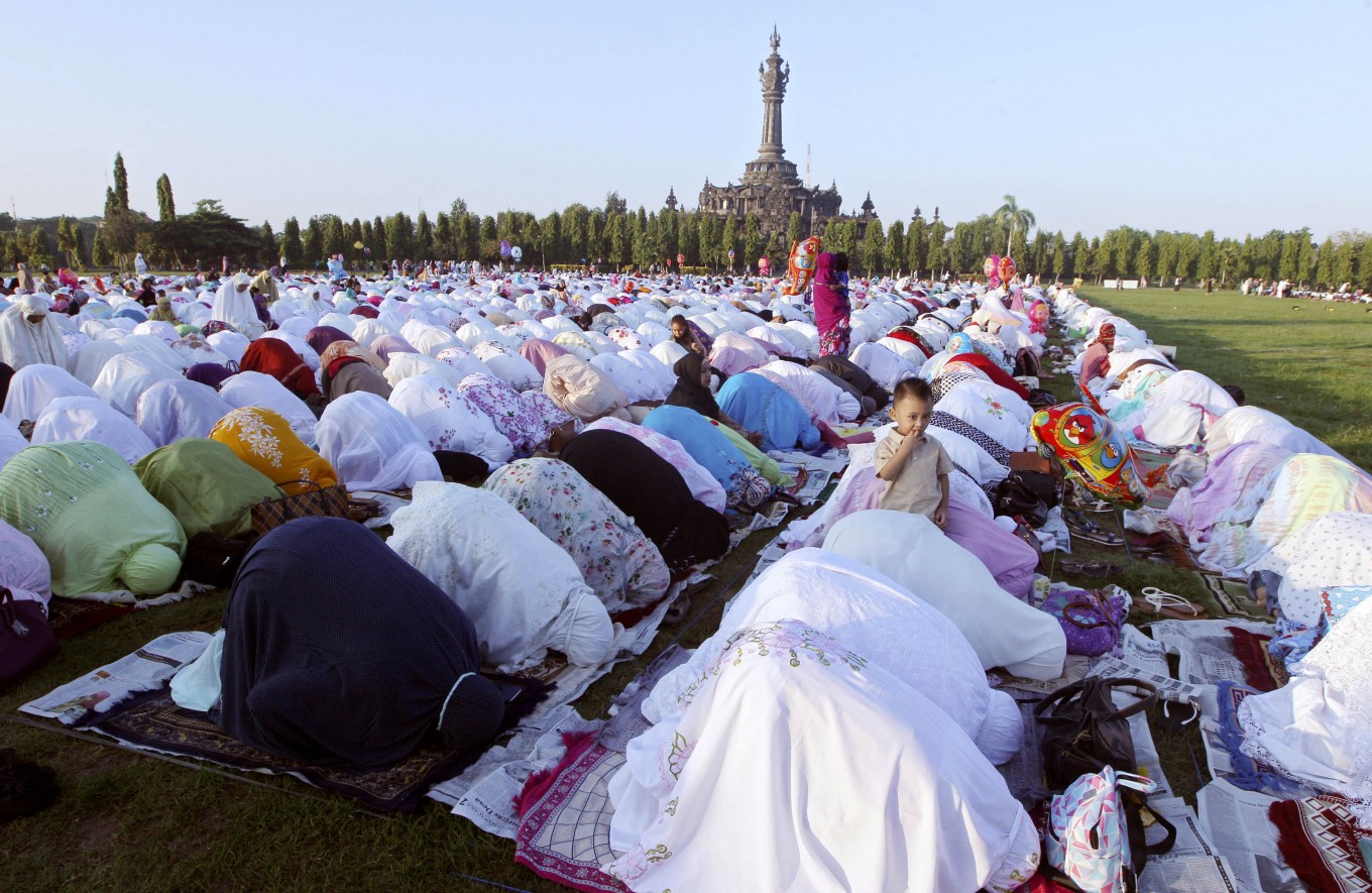 Muslim women perform an Eid al-Fitr prayer marking the end of the holy fasting month of Ramadan in Bali, Indonesia, Wednesday, July 6, 2016. AP Photo/Firdia Lisnawati
