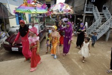 Muslims march during Eid al-Fitr prayers along the Mekong river of Tanong, northeast of Phnom Penh, Cambodia, Wednesday, July 6, 2016.  The Eid al-Fitr celebrations mark the end of the Muslim holy fasting month of Ramadan. AP Photo/Heng Sinith