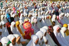 Muslim women wear mukena [head-to-toe prayer gowns] during Idul Fitri prayers in Gumuk Pasir, Parangkusumo, Yogyakarta on Wednesday. JP/ Albertus Magnus Kus Hendratmo