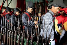 Palace guards return their rifles after the Grebeg Syawal procession. (JP/Dhoni Setiawan)
