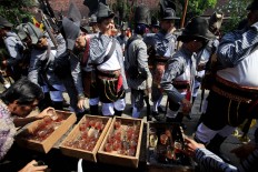 Tea is served to royal guards after the Grebeg Syawal procession at Pratjimosono in the vicinity of the Yogyakarta Palace. (JP/Dhoni Setiawan)
