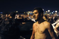 A man, protesting against the coup, stands in Istanbul, early Saturday, July 16, 2016. Turkish President Recep Tayyip Erdogan told the nation Saturday that his government was working to crush a coup attempt after a night of explosions, air battles and gunfire across the capital. Officials said the coup appeared to have failed as Turks took to the streets overnight to confront troops attempting to take over the country. AP Photo/Omer Kuscu