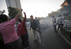 Turkish people celebrate as police officers, loyal to the government secure the area in Istanbul, Saturday, July 16, 2016. Turkish President Recep Tayyip Erdogan declared he was in control of the country early Saturday as government forces fought to squash a coup attempt during a night of explosions, air battles and gunfire that left dozens dead. AP Photo/Emrah Gurel