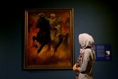 A visitor ponders a painting titled “Pangeran Diponegoro Memimpin Perang” [Prince Diponegoro leads the war] by prominent painter Basoeki Abdullah at the National Gallery. The Jakarta Post/Wienda Parwitasari