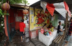 Residents hang out near the entrance gate to Kampung Tambak Bayan.JP/ Tarko Sudiarno