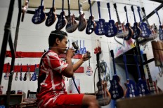 One of Pramono’s workers sprays melamine on a Gibson Les Paul miniature. JP/ Albertus Magnus Kus Hendratmo