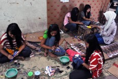 Women apply the stickers on each of the Gibson Les Paul miniatures at the workshop in Klaten. They use stickers to make the work faster to meet the deadline. JP/ Albertus Magnus Kus Hendratmo