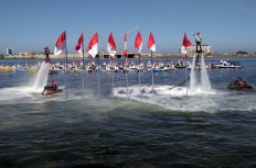 After hoisting red­and­white flags on Losari Beach in Makassar, South Sulawesi on flyboards, two members of the Water Ski and Motor Boat Association (Popsa) salute while hovering in the air. The event was organized by the Makassar Agriculture, Fisheries and Maritime Agency, involving representatives from 11 islands in Makassar and members of the water ski association. Mayor Ramdhan Pomanto attended the ceremony. JP/Andi Hajramurni
