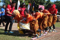 Women prisoners from Bulu prison fall down while participating in a walk-­the­-plank race in Kedungpane prison on Monday, when hundreds of thousands of prisoners in participated in Independence Day celebrations. JP/Suherdjoko
