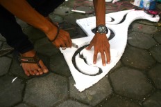 Tono cuts styrofoam to decorate his pedal car before the pedal cars carnival at the South Square in Panembahan during the Alun Alun Selatan Festival. JP/ Aditya Sagita