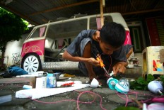 Seno prepares light decorations for a pedal car before the carnival. JP/ Aditya Sagita