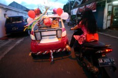 A motorist gives a helping hand [or foot rather] to make the trip to the carnival site faster. JP/Aditya Sagita