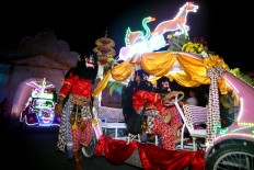 A costumed team operates a pedal car as it passes Plengkung Gading near the South Square. JP/Aditya Sagita
