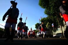 A troop of men wearing royal Javanese soldier attire carry the arem-arem mountain in the kampung. JP/Aditya Sagita