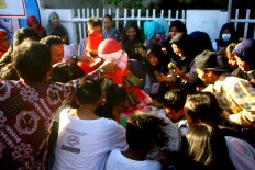Children and adults have fun racing to get the arem-arem arranged like a small mountain. JP/Aditya Sagita