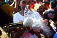 A woman shows off her bounty from the mountain. JP/Aditya Sagita