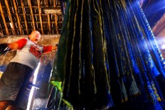 A worker hangs a naturally dyed batik cloth in Bekonang, Sukoharjo, Central Java. JP/Ganug Nugroho Adi.