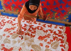 A batik craftswoman draws batik motifs using a brush, a painting technique referred to as “colet”. JP/Ganug Nugroho Adi