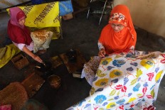 Two artisans work on batik motifs. JP/Ganug Nugroho Adi