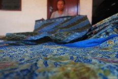 A worker folds a batik cloth dyed with natural ingredients. JP/Ganug Nugroho Adi