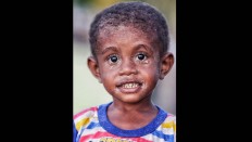 A Namatota child is covered in sand after playing. JP/Wendra Ajistyatama