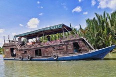 A traditional tongkang boat, once used by illegal loggers, has been converted to accommodate tourists and transport them to Camp Leakey to see the primates.  JP/ Wendra Ajistyatama
