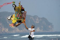A man holds a two dimensional kite at the 2016 National Kite Festival on Parangkusumo Beach in Bantul, Yogyakarta. JP/ Aditya Sagita
