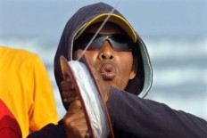 A participant of 2016 National Kite Festival controls his kite. JP/ Aditya Sagita