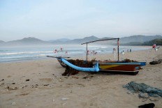A fishing boat waits on the beach. Fishermen only sail at night in the area. JP/Tarko Sudiarno
