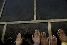 In this Wednesday, Sept. 7, 2016 file photo, Muslim pilgrims reach the Kaaba, Islam's holiest shrine, to touch it for blessing at the Grand Mosque in the Muslim holy city of Mecca, Saudi Arabia. Muslim pilgrims have begun arriving at the holiest sites in Islam ahead of the annual hajj pilgrimage in Saudi Arabia, with some weeping with their hands outstretched for a fleeting touch of the Kaaba. The cube-shaped shrine, at the center of Mecca's Grand Mosque, is the site the world’s 1.6 billion Muslims pray toward five times a day. AP Photo/Nariman El-Mofty