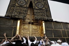 In this Wednesday, Sept. 7, 2016 file photo, Muslim pilgrims touch the golden door of the Kaaba, Islam's holiest shrine, at the Grand Mosque in the Muslim holy city of Mecca, Saudi Arabia. Muslim pilgrims have begun arriving at the holiest sites in Islam ahead of the annual hajj pilgrimage in Saudi Arabia, with some weeping with their hands outstretched for a fleeting touch of the Kaaba. The cube-shaped shrine, at the center of Mecca's Grand Mosque, is the site the world’s 1.6 billion Muslims pray toward five times a day. AP Photo/Nariman El-Mofty