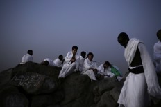 An African man reaches the top of Noor Mountain, where Prophet Muhammad received his first revelation from God to preach Islam, on the outskirts of Mecca, Saudi Arabia, Friday, Sept. 9, 2016. Muslim pilgrims have begun arriving at the holiest sites in Islam ahead of the annual hajj pilgrimage in Saudi Arabia. The Mecca Royal Clock Tower Hotel is seen at center. AP Photo/Nariman El-Mofty