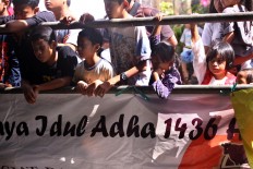 Children observe the animal slaughtering process during Idul Adha celebrations at Jogokariyan Mosque in Yogyakarta on Sept. 12. JP/Aditya Sagita