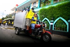 Two staffers ride a motorcycle to distribute meat to local people during Idul Adha celebrations at Jogokariyan Mosque in Yogyakarta on Sept. 12. JP/ Aditya Sagita