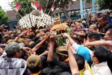 Residents jostle for parts of the male specific offerings. JP/Ganug Nugroho Adi
