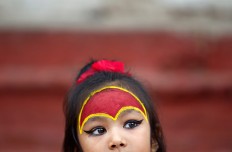 A young Nepalese girl wearing traditional attire waits for the Kumari puja to start at Hanuman Dhoka temple, in Kathmandu, Nepal, Wednesday, Sept. 14, 2016. AP Photo/Niranjan Shrestha