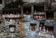 he cliffs are dotted with Tao Tao wooden effigies, representing the deceased. JP/ Agung Parameswara