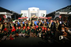 Couples pose together with makeup artists and wedding committee members after they exchanged vows at a mass wedding in the yard of Tugu Station in Yogyakarta on Sept. 6. JP/ Aditya Sagita