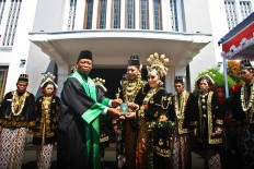 A bride and groom receive their wedding book from the wedding administrator at a mass wedding in front of Tugu Station in Yogyakarta. JP/ Aditya Sagita