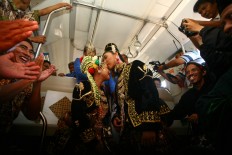 Crysna Marsono kisses his bride Kania Restu Fauzi after reciting their marriage vows onboard the Prambanan express train headed to Solo Balapan station in Surakarta. The pair was one of seven couples that participated in a mass wedding at Tugu Station in Yogyakarta on Sept. 6. JP/ Aditya Sagita