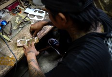A craftsman draws a pattern for a frame on a piece of wood in a home workshop in Bandungrejo, Malang, in East Java. The frames are made by former drug addicts using wood recycled from used furniture. JP/Aman Rochman