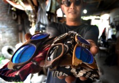Mario Bannet, 32, shows several eye wear frames made by his friends at his workshop in Malang, East Java, on Aug. 15. JP/Aman Rochman