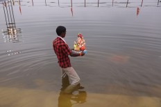 An Indian worker prepares to immerse an idol of elephant-headed Hindu god Ganesha in a lake during Ganesh Chaturthi festival in Hyderabad, India, Tuesday, Sept. 13, 2016. The immersion of idols after worship marks the end of the annual festival. AP Photo/Mahesh Kumar A.
