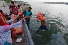 Indian men hold an idol of elephant-headed Hindu God Ganesha and jump into the river Sabarmati to immerse it during Ganesha Chaturthi festival in Ahmadabad, India, Wednesday, Sept. 14, 2016. The ten-day festival is dedicated to the worship of Ganesha. AP Photo/Ajit Solanki