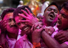A Hindu devotee smears the face of another with colored powder during a procession for the immersion of idols of elephant-headed Hindu god Ganesha in the River Tawi on the last day of the ten-day long Ganesh Chaturthi Festival in Jammu, India, Thursday, Sept. 15, 2016. The last day of the 10-day celebration is the biggest day, with massive crowds singing and dancing as they carry their idols through the streets, to immerse them in the water, an act that symbolizes sending the god back to his mythical home in the snow-capped mountains taking all the worries and problems of his worshippers with him. AP Photo/Channi Anand