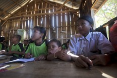 A 2-year-old sister of one of the students joins the class while her parents are working. JP/ Sigit Pamungkas