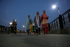 Kashmiri women walk back to their homes after shopping  during a relaxation from strike and curfew in Srinagar, Indian controlled Kashmir, Sunday, Sept. 25, 2016. Kashmir is witnessing the largest protests against Indian rule in recent years, sparked by the July 8 killing of a popular rebel commander by Indian soldiers.  AP Photo/Mukhtar Khan