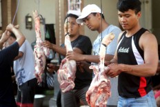 Men participate in a pig slaughtering ritual during penampahan galungan in Banjar Kehen, Denpasar, Bali.  The ritual is performed a day before the festival, as a symbol of cleansing human beings’ souls of animalistic greed. JP/Zul Trio Anggono