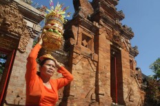 A woman carries offerings on her head at the Pura Jagatnatha Temple as part of the celebrations of the Galungan Festival in Denpasar, Bali, on Sept. 7. The festival is celebrated by Hindus as a victory of good (Dharma) over evil (Adharma). JP/Zul Trio Anggono