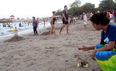 A Balinese woman prays by placing the canang [offerings] on Sanur Beach during umanis galungan on Sept. 8. During Umanis galungan, which is held a day after the Galungan Festival, Hindus forgive one another by visiting relatives and water sources. JP/Zul Trio Anggono